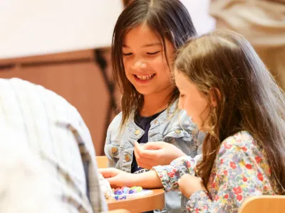 Two children laughing together at a table during Celebration Sunday in Parish Hall