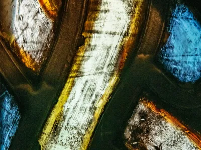 Extreme close up of stained glass with whites, yellows, oranges, and blues