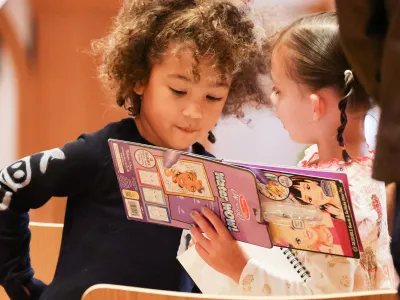 Two children look at an activity book during Family Service at Trinity Commons