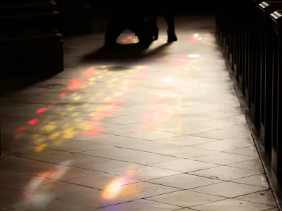 Yellow and red light filters through stained-glass windows and shines on the floor of Trinity Church