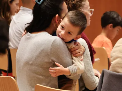 A child hugs their guardian during Family Service at Trinity Commons