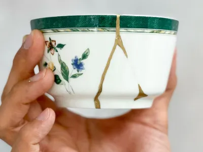 A broken white with floral decoration cup mended with gold