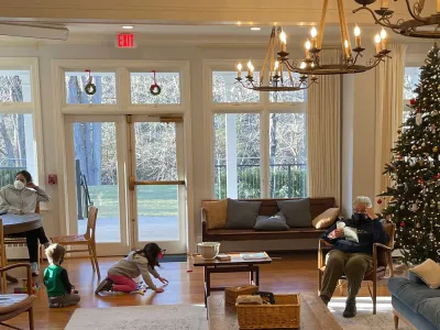 Children and adults spend time near the Christmas tree at Trinity Retreat Center