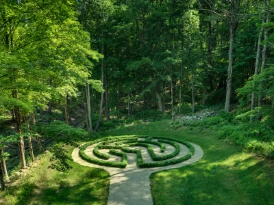 A green forest around a garden labyrinth at the Trinity Retreat Center