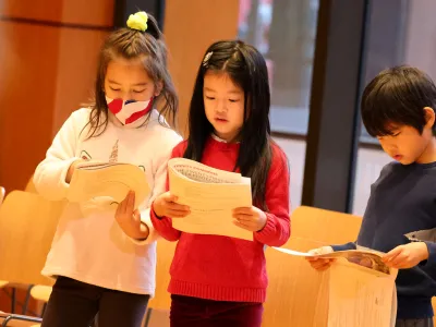 Children looking at their worship bulletins and following along with Family Service