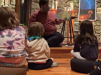Father Matt reads a book to children in the TRC chapel