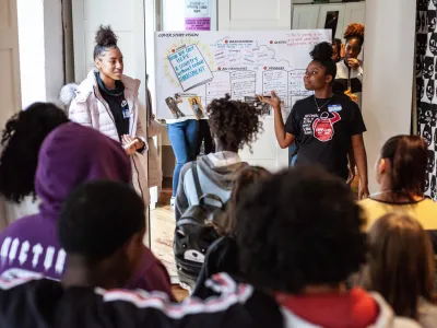 Black girls and LBGTQ+ youth gather in a meeting to discuss a campaign. 