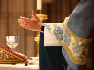 A hand stretched out over the table during Holy Eucharist at Trinity Church