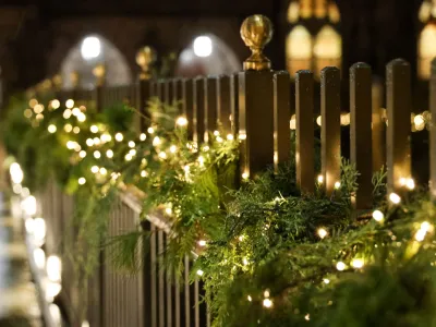 Lighted evergreen boughs line the pedestrian bridge in Trinity Church