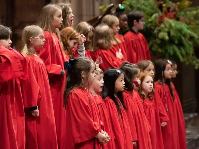 The children's choir in red choir robes singing in Trinity Church