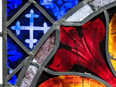 A close-up photo of brightly colored stained glass in Trinity Church, blue, red, warm yellow