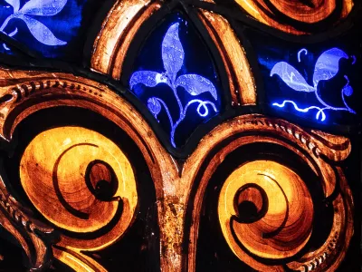 Stained glass with gold swirls and blue plant tendrils