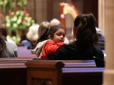 A child and caregiver sitting in a pew during the 9am service at Trinity Church