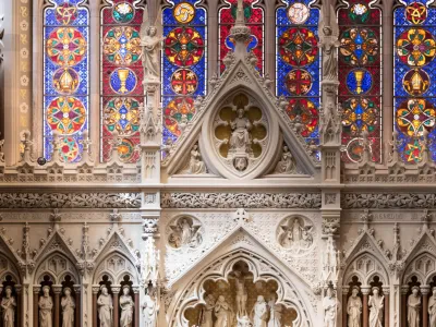 A beam of light streams across the stained glass and reredos in Trinity Church