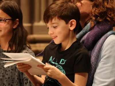 A child reads the worship bulletin with a smile during the 9am service at Trinity Church
