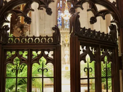 Carved wooden gates open into the Chapel of All Saints at Trinity Church, filled with palms from Palm Sunday