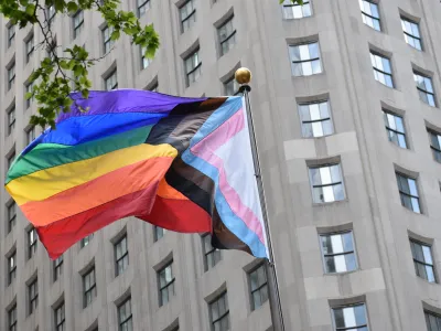 Pride flag with the building in the background