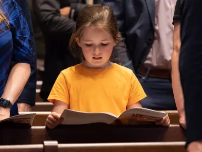 A child following along with the service using the worship bulletin at the 9:15am service