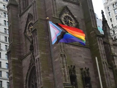 The Progress Pride Flag flies in front of Trinity Church Wall Street