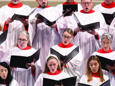 Several choir members in robes sing