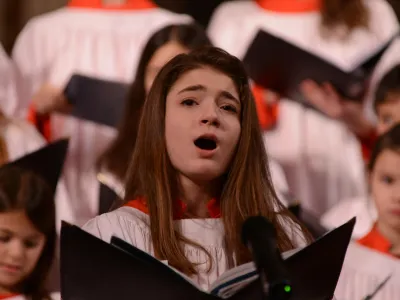 Soloist from the Trinity Youth Chorus sings with a book