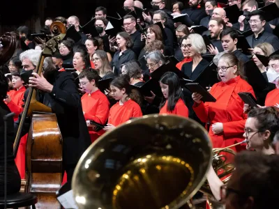 Choir members, a bass and tuba in red and black for holiday concert