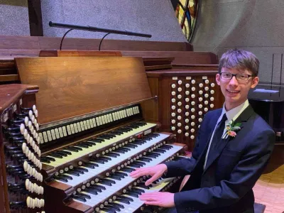 Ethan Haman at an organ in a suit