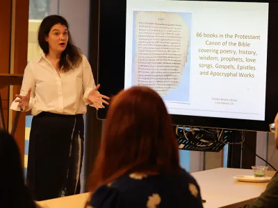 Summerlee Staten stands before a room of listening students at the Foundations course