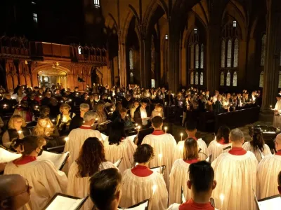 Choir members in white and red robes hold candles in Trinity Church