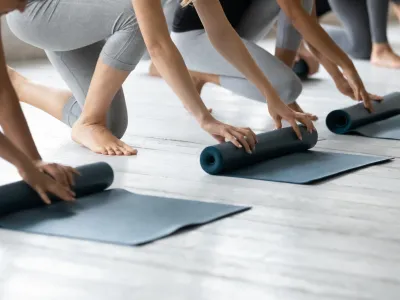 People are folding yoga mats in a line