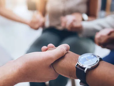 People holding hands in a support group