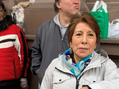 Woman in grey coat stands in front of St. Paul's Chapel