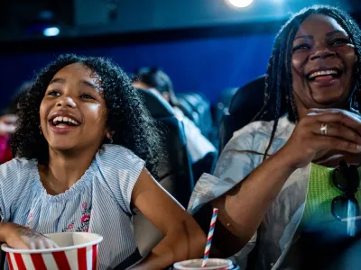 Mother and daughter duo laugh at the movie theater.