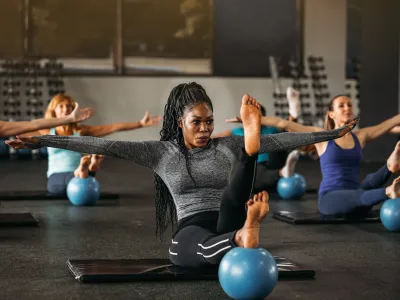 Women of various ages and races engage in a mat pilates class.