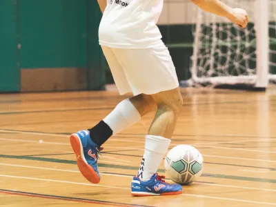 Man kicks soccer ball in gym