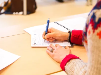 Woman takes notes in classroom