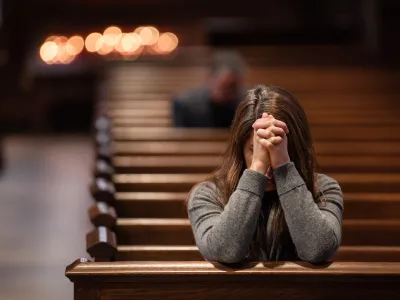 A person prays in a pew in Trinity Church