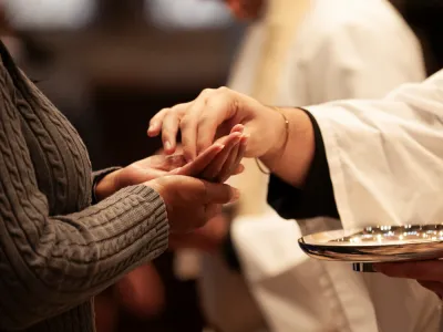 A close-up image of hands serving Communion in Trinity Church