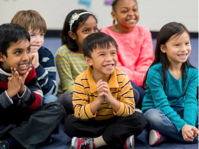 School age kids sit together on the floor 