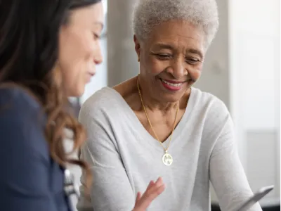 A lady teaches a senior woman about smartphone 