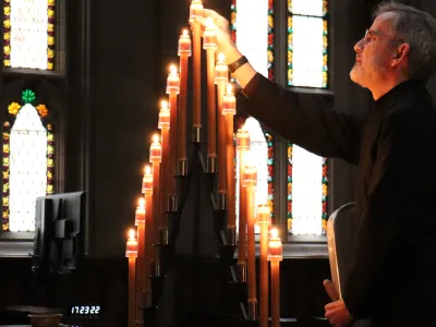 Scott Smith is lighting the candles before the Tenebrae service. 