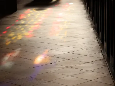 Colorful, stained-glass—filtered light shines on the stone floor of Trinity Church