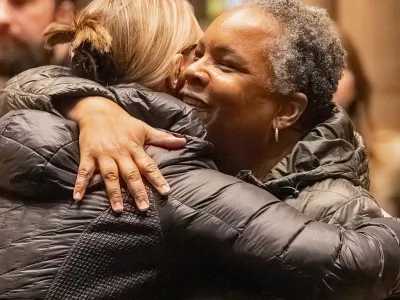 Two smiling parishioners share a hug during Sunday service at Trinity Church