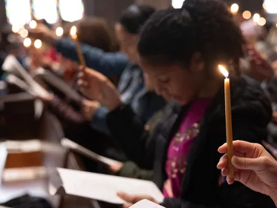 Congregants hold lit candles during a service in Trinity Church