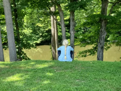 Woman sitting by river