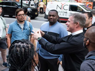 Father Bird talks to a group of students on Broadway