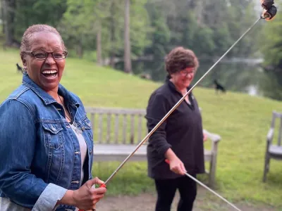Women roasting s'mores at the edge of the Housatonic River