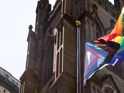 The pride flag with the church in the background.