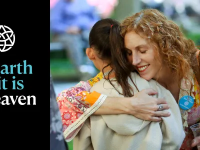 Parishioners hug in the churchyard with the words "on earth as it is in heaven" overlayed