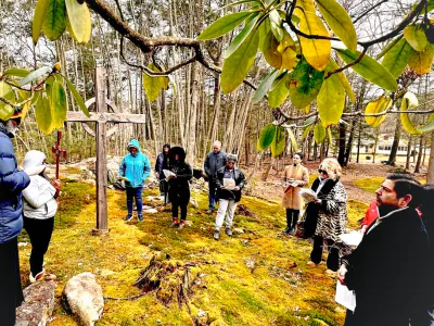 People pray in the woods